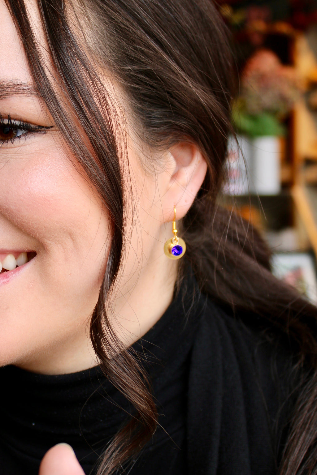 Model wearing Allie Bee coin and gem earrings in royal blue