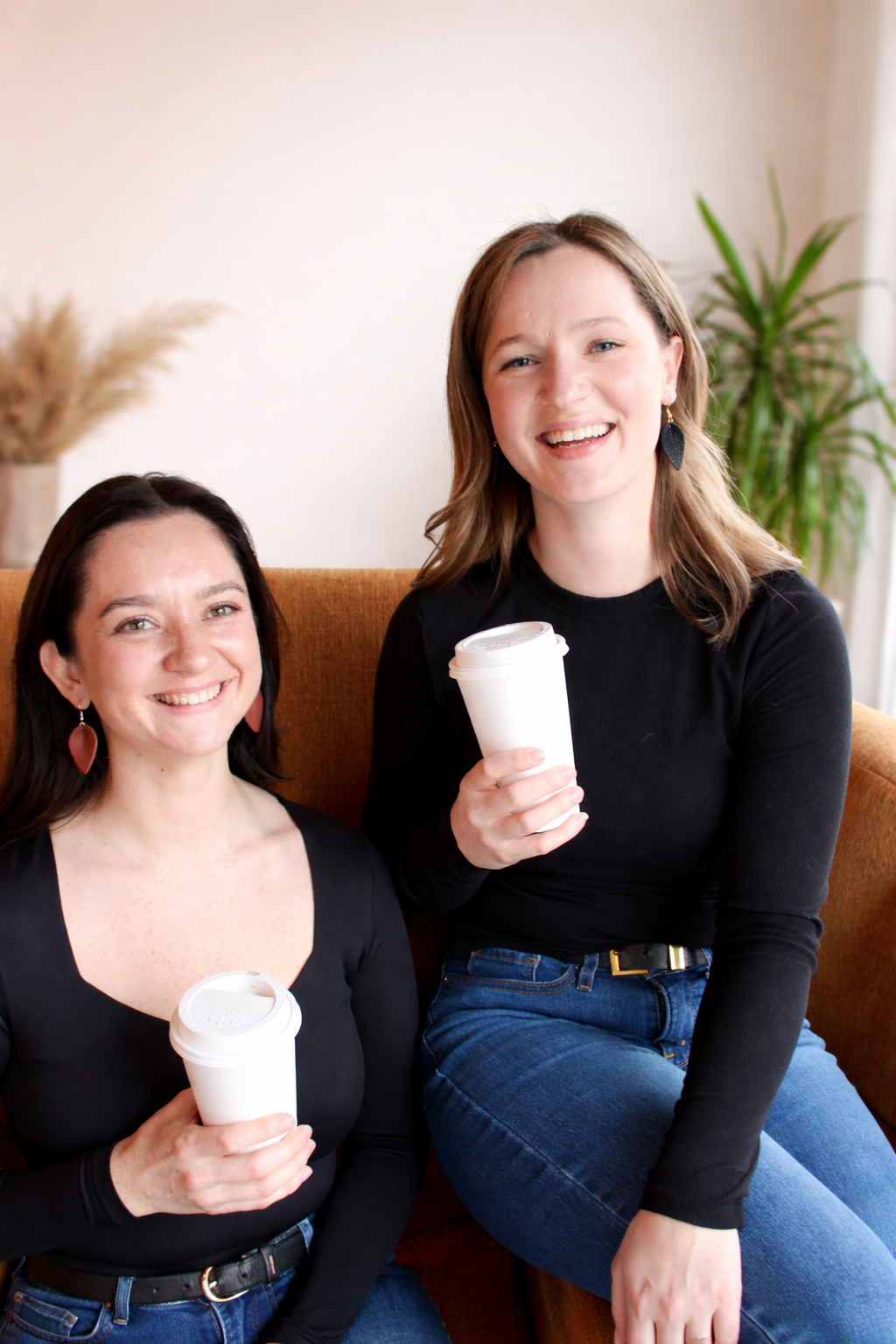 two models smiling wearing handmade leather earrings