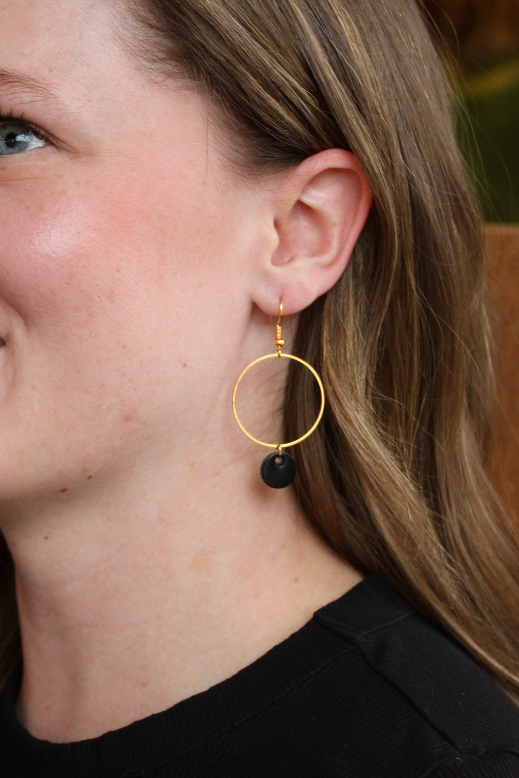 Model wearing Gabby Bee hoop and leather moon earrings in black