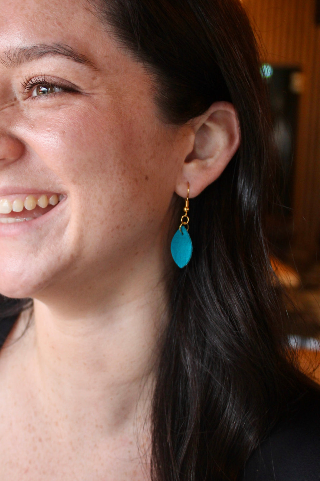 Model wearing Kaity Bee tiny suede feather earrings in turquoise