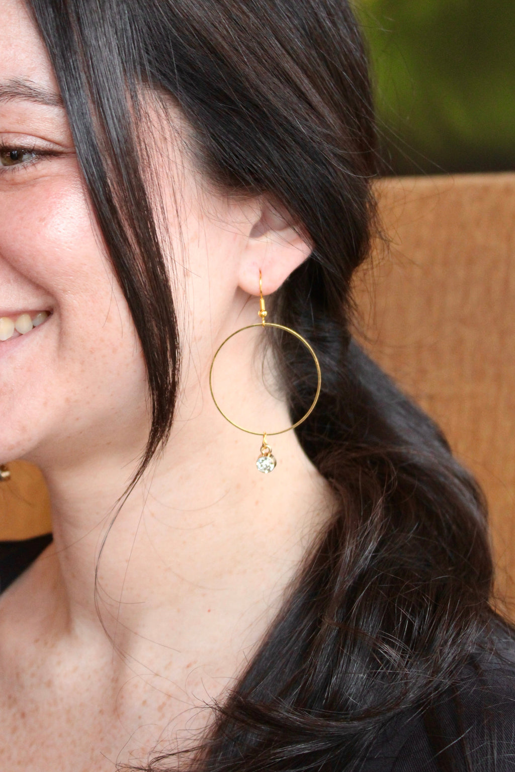 Model wearing Sophie Bee hoop and gem earrings in gold with white gem