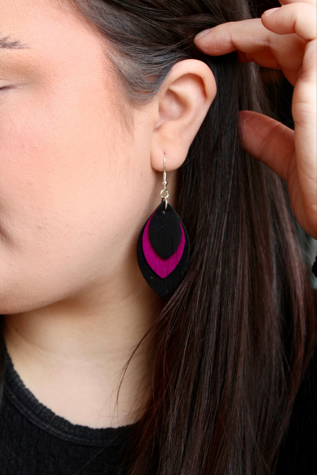 Model wearing Sylvie Bee triple suede feather earrings in black and magenta